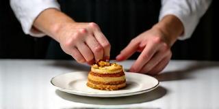 Chef styling plated dessert under camera lights