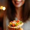 Happy client holding a canape at cocktail party